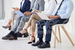 Unknown group of diverse businesspeople waiting for interview and using technology. Team of applicants sitting together. Professional candidates in line for job opening, vacancy and office opportunity