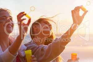 Blowing their cares away. Shot of a group of female friends using the breeze to blow bubbles.