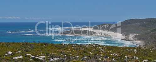 Copyspace at sea with a clear blue sky background and calm coast in Western Cape, South Africa. Ocean waves crash onto the shore at a beach. A peaceful scenic landscape for a relaxing summer holiday