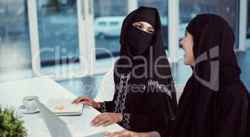 Theyre a perfect pair. two young arabic businesswomen working on a laptop in their office.