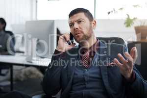 Explain please.... a mature businessman using a mobile phone in a modern office.