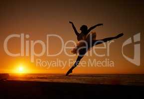 Silhouette of a ballet dancer in tutu dancing on the beach at sunset. Graceful ballerina dancing and jumping outdoors