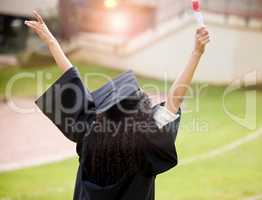 I have even further to soar. Rearview shot of a young woman cheering on graduation day.
