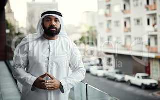 Taking a break on the balcony. Cropped portrait of a businessman dressed in traditional Islamic clothing working on his office balcony.