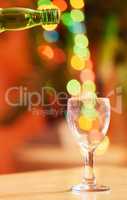 Closeup of a glass against a vibrant bokeh background. One transparent glass on a table. Crockery used to enjoy alcoholic beverages such as beer or cocktails in a cafe, nightclub, bar or at home