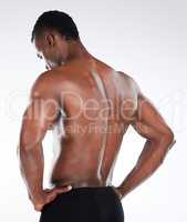 I like my back well defined. Shot of an unrecognisable man standing alone in the studio and posing shirtless.