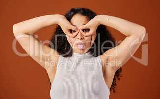 Everyone loves a little quirky. Cropped portrait of an attractive young woman making a face in studio against a red background.