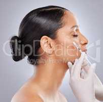 Plumping up those cheek bones. Shot of an attractive young woman getting filler injections in the studio.