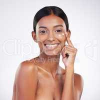 Follow my beauty guide and see the results. Studio portrait of an attractive young woman applying lotion to her face against a grey background.