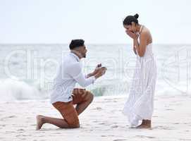 Will you marry me. Full length shot of a handsome young man proposing to his girlfriend on the beach.