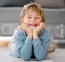 Portrait happy child looking at camera with smiling face. Adorable caucasian kid lying on the floor and relaxing at home. Happy childhood