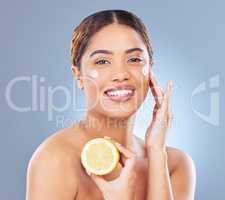 Get the radiant skin youve always wanted. Shot of a young woman holding half a lemon against a grey background.