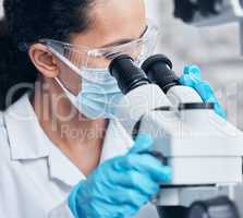 Im one step closer to the cure. Shot of a young scientist using a microscope in a lab.