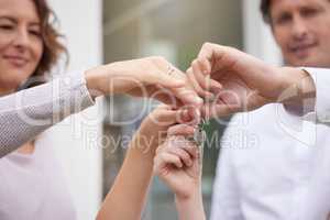 Closeup hands of happy married couple holding up house keys. Man and woman holding keys to new house or apartment. Young family buying or renting new house and moving in together, loan or mortgage