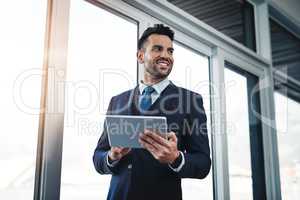 Technology is new frontier in business. a handsome male executive working in a modern office.