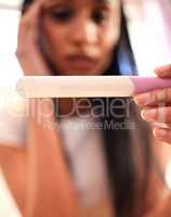 Im not ready for this. a young woman taking a pregnancy test at home.