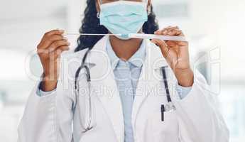 Closeup african american woman doctor wearing a mask and holding a swab test in the hospital. Testing for the corona virus pandemic. Stop the spread of covid 19 and get tested. Health and medicine