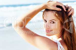 Pretty young female posing on the beach. Closeup portrait of a pretty young female posing on the sea shore.