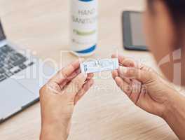 Closeup shot of a mixed race unrecognizable woman holding a rapid test kit. Female office worker holding a corona virus testing kit at work for effective, fast, test results