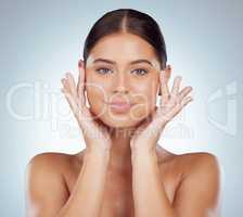 Portrait of beautiful woman with smooth glowing skin and copyspace posing topless and touching her face. Caucasian model isolated against grey studio background. Healthy skincare and self care routine