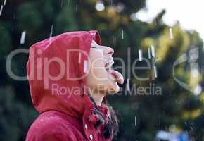 I feel like Im a kid again, the rain does that. a young woman sticking out her tongue to feel the rain outside.