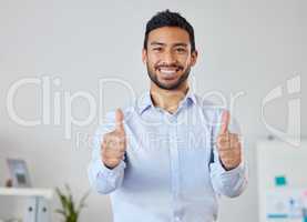 Smiling businessman showing thumbs up sign with copyspace. Portrait of asian professional standing alone and using hand gesture to symbol good luck. Mixed race man endorsing, feeling excited in office