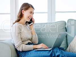 Yeah Im looking at it right now. Cropped shot of an attractive young woman making a phonecall while relaxing on the sofa at home.