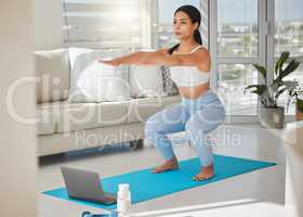 I will succeed in life, not immediately but definitely. Shot of a sporty young woman using a laptop and doing squats while exercising at home.