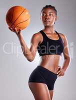 How many hoops can you shoot. Studio shot of a sporty young woman posing with a basketball against a grey background.