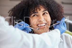 Above shot of a beautiful young african american woman with an afro looking at the dentist at her dental appointment. Having her checkup to prevent tooth decay and gum disease. Oral and dental hygiene