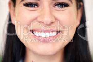 Closeup of a confident young caucasian woman with a bright and beautiful smile. One female only looking happy and cheerful. Brush regularly for healthy teeth free of cavities and gum disease