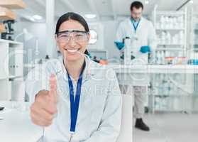 My experiment has been a roaring success. Portrait of a young scientist showing thumbs up in a lab.