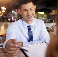 Just initial here.... a handsome mature male car salesman talking to a customer in his office at the car dealership.