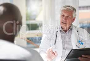 This is serious. Shot of a mature doctor having a checkup with a patient at a hospital.