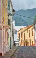 Narrow street or alley between colorful buildings in Santa Cruz, de La Palma. Bright and vibrant classical architecture in a small city or village. Beautiful houses or homes with a vintage design