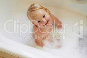 Bath time is the best when its filled with bubbles. Portrait of an adorable little girl having a bubble bath.