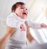 a mixed race adorable cute little baby laughing. Young mother playing with her newborn baby while laughing and enjoying bonding with her infant at home. Single mom happy on maternity leave