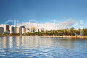Beautiful landscape of a city near the beach and blue sky for a holiday or vacation destination. Cityscape surrounded by nature, trees, the sea, and the ocean. Scenic view of the urban scene by water