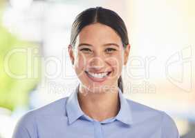 Closeup portrait of a happy mixed race smiling female working. Face shot of a cheerful positive hispanic woman enjoying her corporate office job while wearing formal clothes and showing her teeth