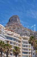 Copy space of Lions Head in Cape Town South Africa against a blue sky background from below. Panoramic of an iconic landmark and travel destination close to coastal apartment buildings and properties