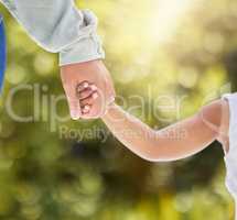 Hold my hand tightly. Shot of an unrecognizable child and parent holding hands in nature.