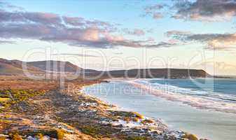 Seascape, lanscape, scenic view of Hout Bay in Cape Town, South Africa at sunrise. Blue ocean and sea with mountians in the morning. Beach travel destination or vacation location for a holiday