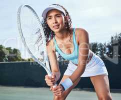 I never skip a day to train. Shot of an attractive young woman standing alone and getting ready to hit the ball during a game of tennis.