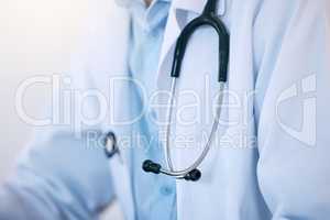 Closeup of one male doctor or cardiologist wearing a white lab coat with stethoscope as uniform for work in a hospital or clinic. Trusted medical practitioner dedicated to the healthcare of patients