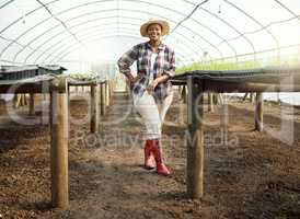 Full body of young farmer in a garden. Portrait of a proud farmer in her greenhouse. Happy african american farmer. Young farmer standing in her garden. Farm employee standing in a nursery