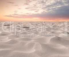 Beach sand dunes in nature with moody twilight sky background and copyspace. Closeup of a scenic landscape outdoors with grainy surface texture. Calm desert to explore for travel and tourism