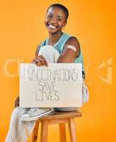 African american covid vaccinated woman showing plaster on arm, holding poster. Portrait of smiling black woman isolated against yellow studio background with copyspace. Promote corona vaccine on sign