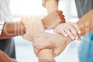 Closeup of diverse group of people holding each others wrists in a circle to express unity, support and solidarity. Connected hands of multiracial community linked for teamwork in a huddle. Society join together for collaboration and equality