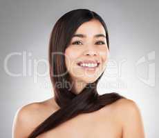 Trust the process. Studio portrait of a beautiful young woman showing off her long silky hair against a grey background.