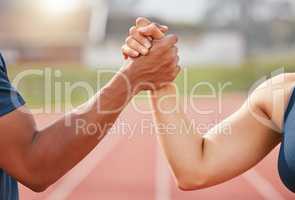 Youve got my support. two unrecognizable athletes shaking hands in solidarity while standing out on track.